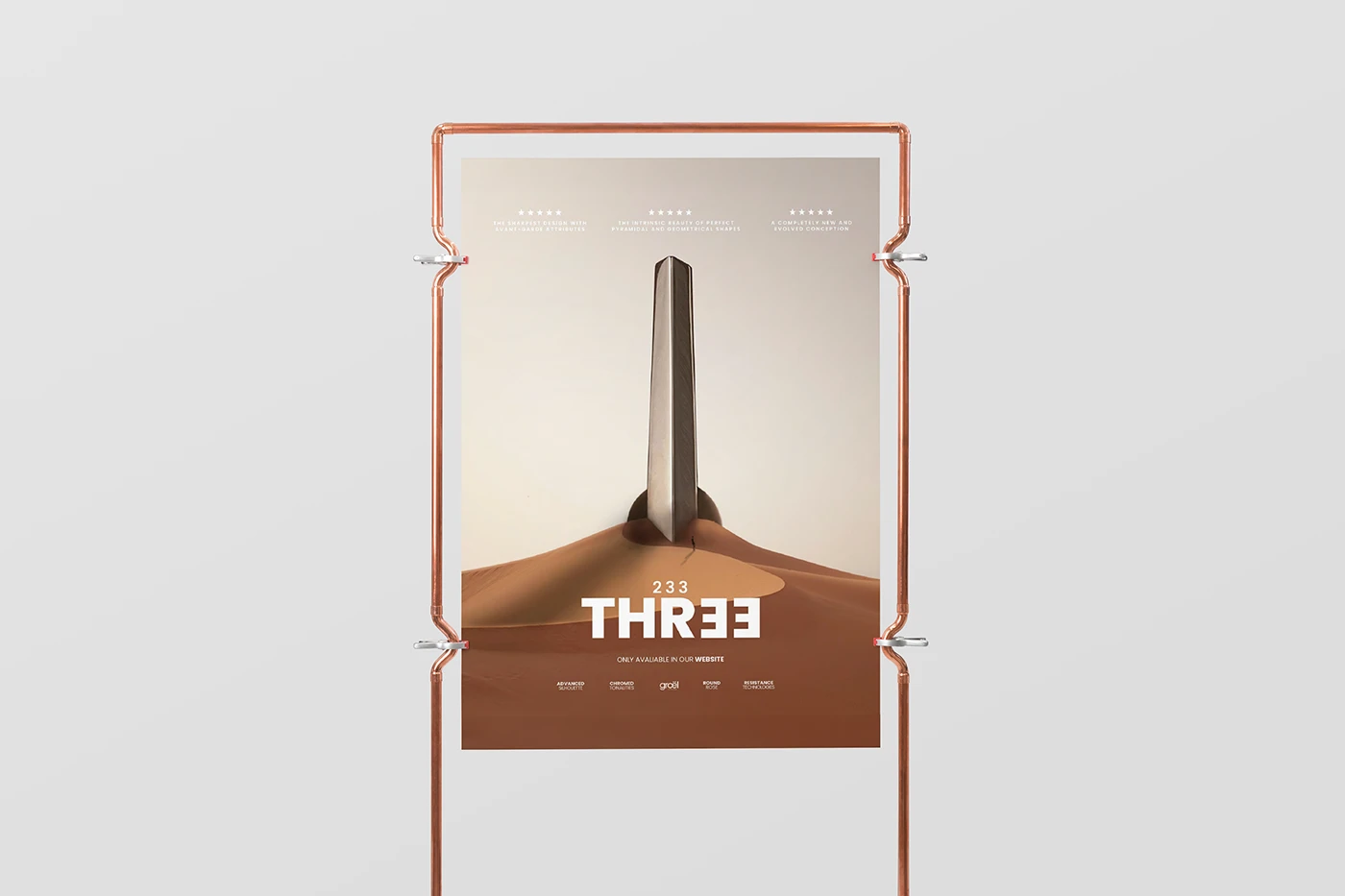 Póster del modelo Three colgado en una estructura de cobre: un obelisco de metal clavado en una duna del desierto